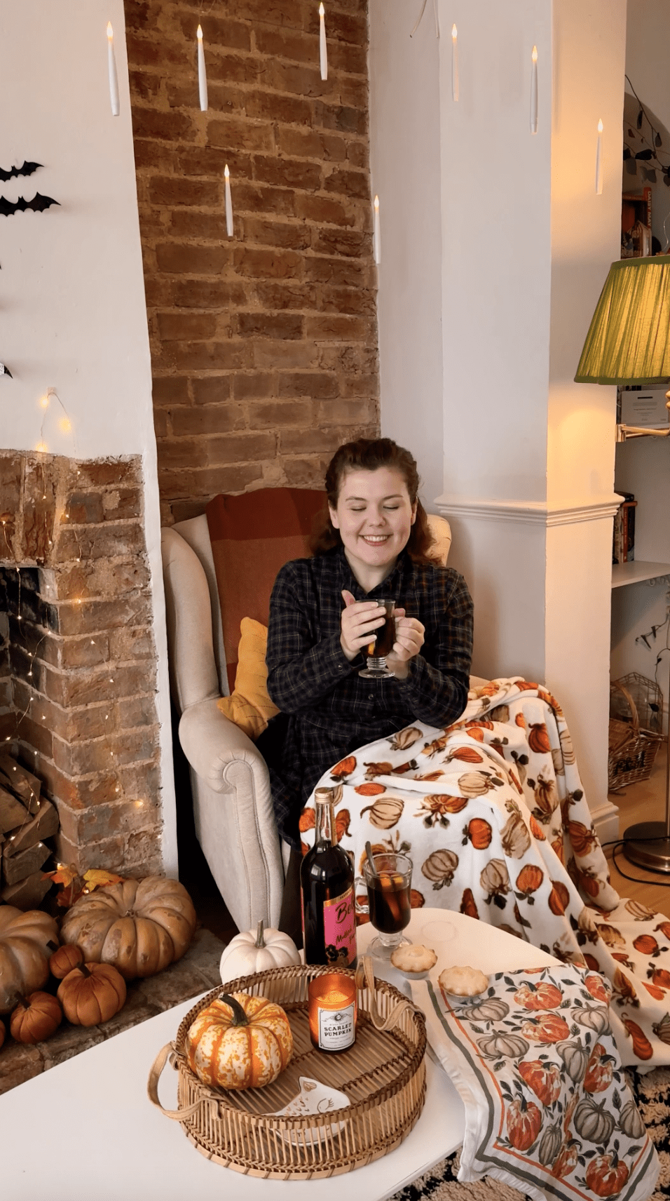 a girl sat drinking belvoir farm mulled winter punch in a cosy autumnal lounge
